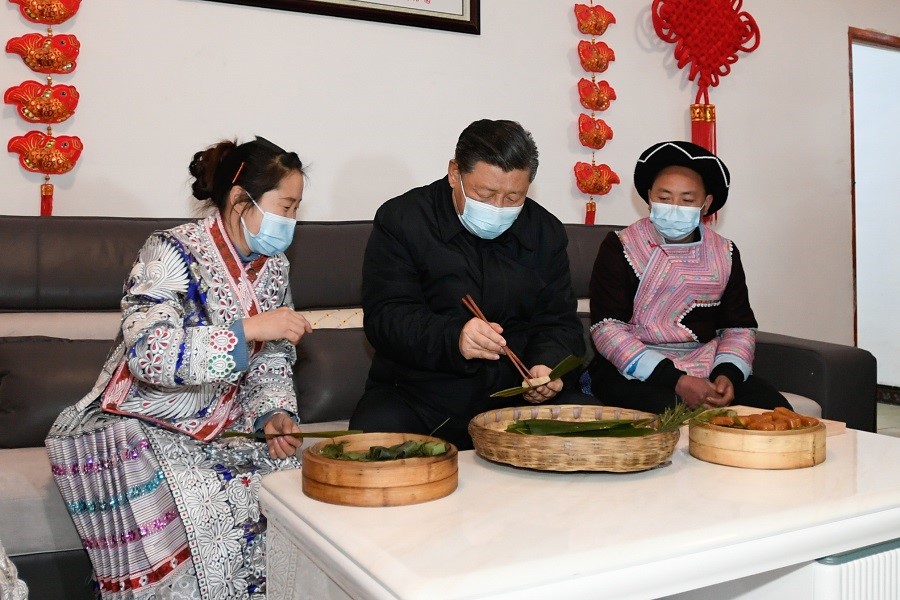 2021年2月3日下午，習近平在貴州畢節(jié)市黔西縣新仁苗族鄉(xiāng)化屋村苗族村民趙玉學家，同一家人邊聊家常邊制作當?shù)貍鹘y(tǒng)節(jié)日食品黃粑。新華社記者 李學仁 攝